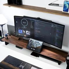 a computer monitor sitting on top of a wooden shelf