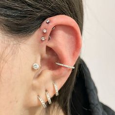 a woman with three ear piercings on her left side and one behind the ear