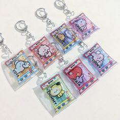 hello kitty keychains are hanging on a white table with other items in them