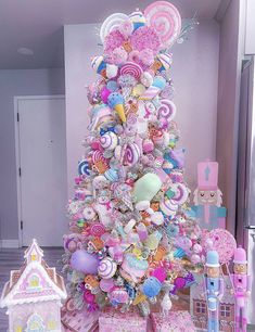 a pink christmas tree decorated with lollipops, candy and candies is shown