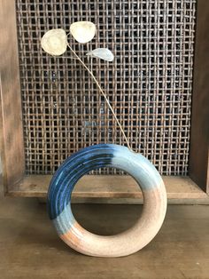 a blue and white vase sitting on top of a wooden shelf next to a wall