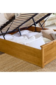 a bed with a wooden frame and mattress in the bottom section, on top of a rug