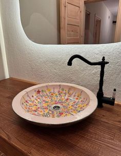 a bathroom sink sitting on top of a wooden counter next to a faucet