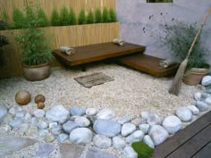 a small garden with rocks, gravel and plants in the center is displayed on an outdoor patio