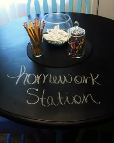 a black table with writing on it that says homework station and pencils in a glass bowl