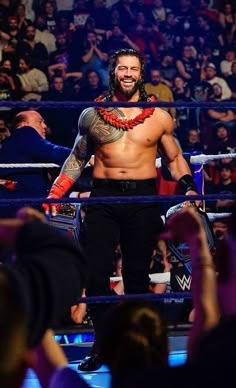 a man standing in the middle of a wrestling ring