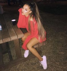 a woman sitting on top of a wooden bench