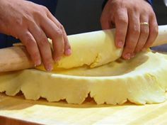 a person is kneading dough on a cutting board