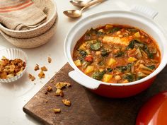 there is a bowl of soup on the table next to other dishes and utensils