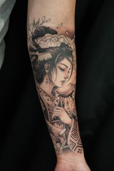 a woman with a geisha tattoo on her arm is holding a flower in her hand