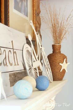 a white shelf topped with vases filled with blue and white balls next to a wooden sign