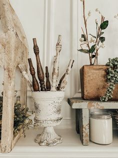 a white vase filled with bottles sitting on top of a shelf next to other items