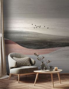 a living room with birds flying over the water wallpaper and two chairs in front of it