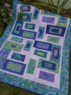 a blue and green quilt on the ground