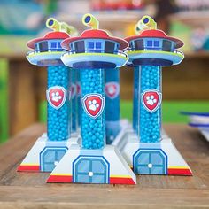 two blue candy dispensers sitting on top of a wooden table