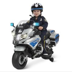 a young boy riding on the back of a police motorcycle