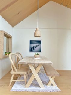 a wooden table and two chairs in a room