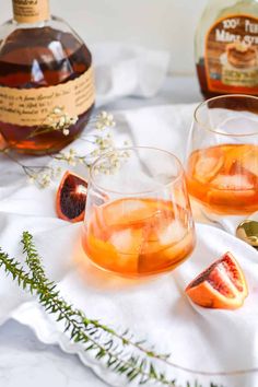 two glasses filled with blood orange punch on top of a white cloth