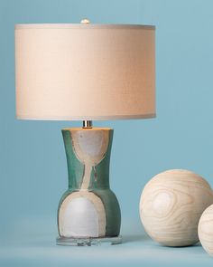 a table lamp sitting next to two wooden balls