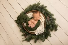 a newborn baby is curled up in a wreath