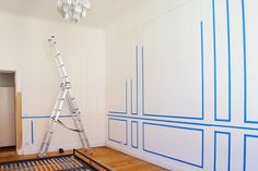 a room with blue lines painted on the walls and a ladder up to it's ceiling