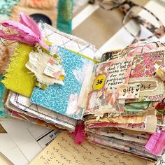 an open book sitting on top of a table covered in lots of different types of papers