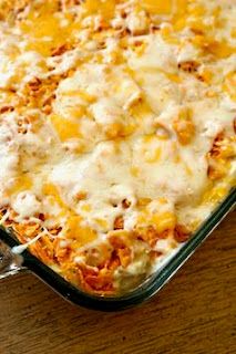 a casserole dish with cheese and meat in it on a wooden counter top