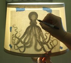 someone is drawing an octopus on a lamp shade