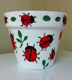 a flower pot with ladybugs painted on it