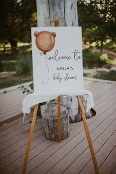 a welcome sign is on an easel outside