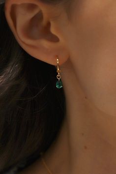 Treat yourself or a special someone to these beautiful birthstone earrings. Our signature huggie supports a vivid teardrop shape in every birthstone color, making them a perfect present. Show your friends and loved ones you care with this stylish and thoughtful accessory. Also available in Silver! Details: - Gold plated brass - Birthstone cz charm SKU: E1590G Materials+Care Gold Earrings Emerald, Gold And Green Earrings, Gold Teardrop Hoop Earrings For May Birthstone, Gold Teardrop Hoop Earrings With Emerald, Gold Teardrop Hoop Earrings With Birthstone, Teardrop Earrings For May Birthstone Gift, Teardrop Hoop Earrings As May Birthstone Gift, May Birthstone Teardrop Earrings, 14k Gold Filled Birthstone Teardrop Earrings