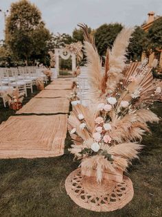 an outdoor ceremony setup with pamodia, pamodia grass and white flowers