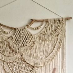 a white wall hanging with beads and tassels