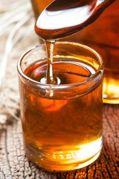 honey being poured into a glass jar