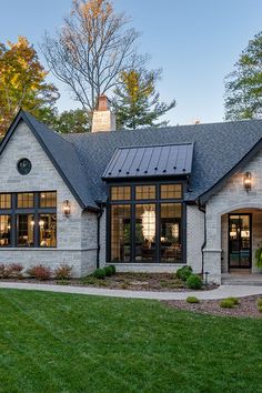 a house with a solar panel on the roof and two windows in front of it