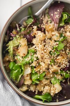 a salad with sesame seeds and lettuce in a bowl on top of a table