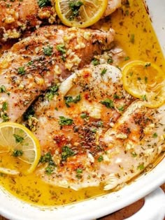 chicken with lemons and herbs in a white casserole