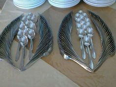 two silver forks and spoons sitting next to each other on top of a table