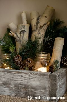 a wooden box filled with candles and pine cones