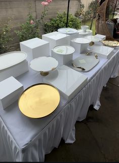 a table topped with white and gold plates