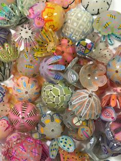 there are many different colored glass balls in the pile together and one has a butterfly on it