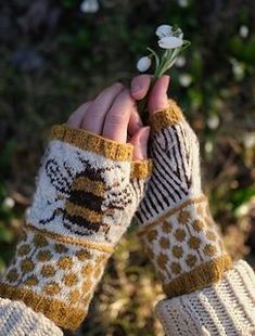 a person wearing mitts holding a flower in their left hand with the other hand