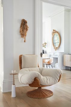 an egg chair in the middle of a living room with white walls and wood floors