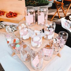 there are many glasses on the table with tags attached to them and some paper hearts