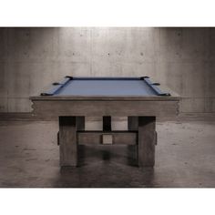 a pool table in an empty room with concrete walls