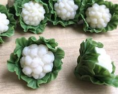 several pieces of cauliflower are arranged in the shape of leaves on a table