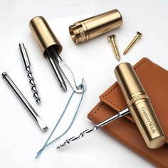 several different types of tools are laid out on a white surface with brown leather pouch