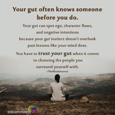 a person sitting on top of a grass covered field next to a hill with the words, your gut often knows someone before you do