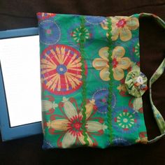 a small purse with a flower design on it and a blue book in front of it