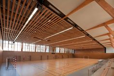 an indoor basketball court with wooden slats on the ceiling